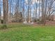 Expansive backyard featuring lush green grass, mature trees, and a cozy fire pit area for entertaining at 9904 Duane Ct, Huntersville, NC 28078