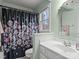 Bathroom with light green walls, white vanity and shower with floral curtain at 9904 Duane Ct, Huntersville, NC 28078