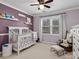 Bedroom with purple walls, white crib, and large window at 9904 Duane Ct, Huntersville, NC 28078