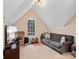 Finished bonus room featuring a dormer window and gray tufted couch at 9904 Duane Ct, Huntersville, NC 28078