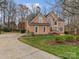 Spacious brick home with a long driveway, complemented by lush greenery and mature trees at 9904 Duane Ct, Huntersville, NC 28078