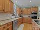 Bright kitchen features wooden cabinetry, granite countertops, stainless steel appliances, hardwood floors and a large window at 9904 Duane Ct, Huntersville, NC 28078