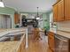 Open kitchen and dining area with stainless steel appliances, granite countertops, hardwood floors and views into the living room at 9904 Duane Ct, Huntersville, NC 28078