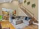 Spacious open-concept living room with hardwood floors, large sectional sofa, staircase and view to the kitchen at 9904 Duane Ct, Huntersville, NC 28078