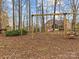 Backyard view of a wooden swing set, providing hours of outdoor fun for children at 9904 Duane Ct, Huntersville, NC 28078