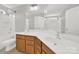 Well-lit bathroom with dual sinks, hardwood cabinets, and a large mirror at 11000 King George Ln, Waxhaw, NC 28173