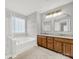 Well-lit bathroom featuring double sinks, a soaking tub, walk-in shower, and updated fixtures at 11000 King George Ln, Waxhaw, NC 28173