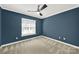 Neutral bedroom offers a ceiling fan and light filled window at 11000 King George Ln, Waxhaw, NC 28173