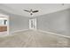 Carpeted bedroom with ceiling fan, doorway to en suite bathroom, and access to the upstairs hallway at 11000 King George Ln, Waxhaw, NC 28173