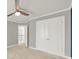 Carpeted bedroom featuring double closets, neutral paint, a ceiling fan, and access to the hallway at 11000 King George Ln, Waxhaw, NC 28173