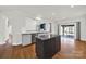 Well-lit kitchen with a kitchen island, hardwood floors, gray cabinets, stainless steel appliances and a view to living area at 11000 King George Ln, Waxhaw, NC 28173