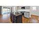 Well-lit kitchen featuring a kitchen island, gray cabinets, hardwood floors, and stainless steel appliances at 11000 King George Ln, Waxhaw, NC 28173