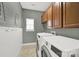 Functional laundry room with washer, dryer, utility sink, and ample cabinet space for storage at 11000 King George Ln, Waxhaw, NC 28173