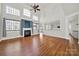 Spacious living room with hardwood floors, large windows, fireplace, and view into the kitchen at 11000 King George Ln, Waxhaw, NC 28173