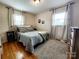 Comfortable bedroom with hardwood floors, patterned bedding, and natural light from two windows at 114 Eller Rd, Gastonia, NC 28056