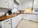 Well-lit kitchen with white cabinets, wood countertops, and classic tile flooring at 114 Eller Rd, Gastonia, NC 28056