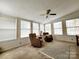 Bright sun room featuring neutral carpet, ceiling fan, and multiple windows for ample natural light at 114 Eller Rd, Gastonia, NC 28056