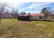 Scenic backyard with red-roofed home, screened porch, shed, and grassy lawn at 115 Setter Ct, Statesville, NC 28625