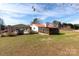 Spacious backyard with a metal roof home, carport and additional outbuildings at 115 Setter Ct, Statesville, NC 28625