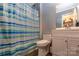 Clean bathroom with white vanity and tiled shower with blue and white curtain and gray walls at 115 Setter Ct, Statesville, NC 28625