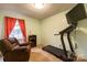 Bright bedroom with comfortable chair, treadmill, and natural light from the window at 115 Setter Ct, Statesville, NC 28625