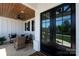 Charming covered front porch with stone floor, comfortable seating, and modern ceiling fan at 129 Ryleigh Dan Pl, Mooresville, NC 28115
