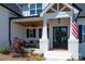 Charming covered front porch with comfortable seating, wood ceiling, and stylish black double doors at 129 Ryleigh Dan Pl, Mooresville, NC 28115