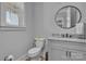 Well-lit half bathroom featuring a modern vanity with granite countertop and stylish round mirror at 129 Ryleigh Dan Pl, Mooresville, NC 28115