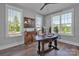 Bright home office with hardwood floors, modern desk, and three large windows providing ample natural light at 129 Ryleigh Dan Pl, Mooresville, NC 28115