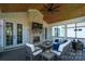 Relaxing screened porch with a stone fireplace, TV, wood ceiling, and comfortable seating at 129 Ryleigh Dan Pl, Mooresville, NC 28115