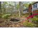 Backyard pond featuring natural rock borders, vibrant azaleas, and a view of the house and surrounding trees at 140 Rustic Way Ln, Mooresville, NC 28117