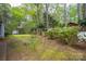 A spacious backyard featuring mature trees, lush greenery, a playset, and colorful blooming bushes at 140 Rustic Way Ln, Mooresville, NC 28117