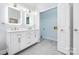 Bright bathroom featuring double sinks with white cabinets and doorway to laundry room at 140 Rustic Way Ln, Mooresville, NC 28117