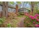 Charming home exterior with brick accents, blooming azaleas and a quaint brick pathway through lush greenery at 140 Rustic Way Ln, Mooresville, NC 28117