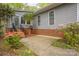 Home exterior featuring a concrete front porch with brick foundation, steel railing, and flowering shrubs at 140 Rustic Way Ln, Mooresville, NC 28117