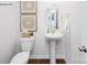 The powder room features a pedestal sink, oval mirror, and decorative wall art at 1416 6Th Ne St, Hickory, NC 28601