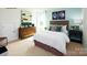Comfortable bedroom with wooden dresser, framed posters, carpet, and nightstand at 1416 6Th Ne St, Hickory, NC 28601