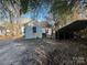 Backyard of a white home with a detached carport and dense foliage at 148 Center St, Chester, SC 29706