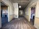 Spacious hallway with wood floors and visible doorways to other rooms in need of repair at 148 Center St, Chester, SC 29706