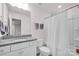 Clean bathroom showcasing single sink vanity with granite counter, tiled floor, and shower with curtain at 155 Autumnwood Rd, Troutman, NC 28166