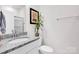 Well-lit bathroom with a granite countertop vanity, modern faucet, and glass-enclosed shower at 155 Autumnwood Rd, Troutman, NC 28166