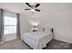 Comfortable bedroom with large window offering natural light, ceiling fan, and soft carpet at 155 Autumnwood Rd, Troutman, NC 28166