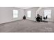 Spacious bonus room with neutral carpet, bright windows, and versatile layout for various activities at 155 Autumnwood Rd, Troutman, NC 28166