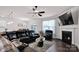 Inviting living room featuring a fireplace, large TV, and comfortable black leather seating at 155 Autumnwood Rd, Troutman, NC 28166