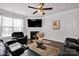 Comfortable living room with a fireplace, TV, plush rug, and black leather seating, bathed in natural light at 155 Autumnwood Rd, Troutman, NC 28166
