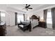 Elegant main bedroom featuring tray ceiling, decorative ceiling fan, with carpet flooring and natural light at 155 Autumnwood Rd, Troutman, NC 28166