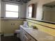 Bathroom with yellow tile, white vanity, and a mirror at 314 Little St, Lincolnton, NC 28092