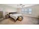 Comfortable bedroom with neutral decor, ceiling fan, three windows, carpet and upholstered storage bench at 3899 Center Place Dr, Harrisburg, NC 28075