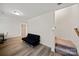 Open room with wood-look floors, black sofa, a desk, stairs, and neutral walls at 3899 Center Place Dr, Harrisburg, NC 28075
