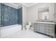 Bright bathroom featuring a soaking tub with blue accent wall and a gray vanity at 4008 Nettie Ct # 3, Charlotte, NC 28211